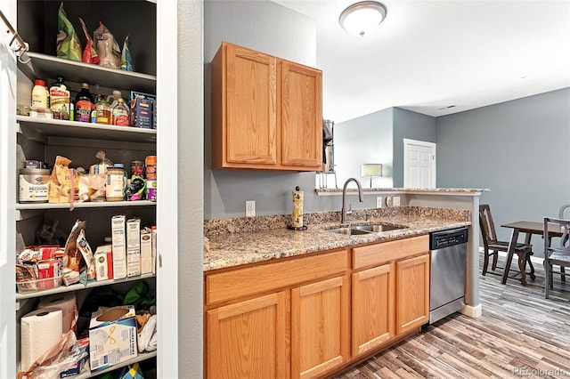 474 Black Feather Loop Unit 406, Castle Rock, CO 80104 - kitchen featuring stainless steel dishwasher, light wood finished floors, light stone countertops, and a peninsula