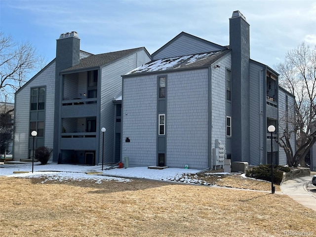 exterior space featuring central AC unit and a chimney