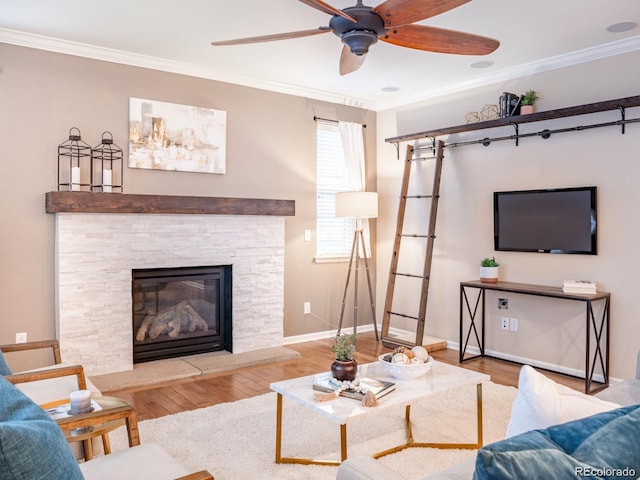 3472 Harvard Pl, Broomfield, CO 80023 - living area featuring crown molding, wood finished floors, a ceiling fan, baseboards, and a stone fireplace