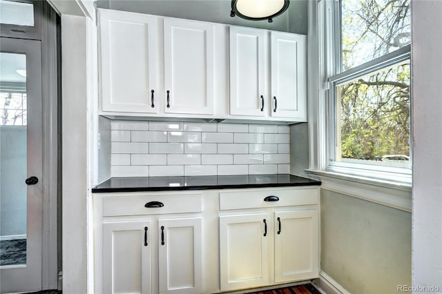 bar with backsplash, healthy amount of natural light, and baseboards
