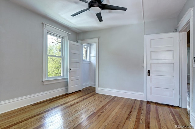 spare room with light wood finished floors, plenty of natural light, baseboards, and ceiling fan