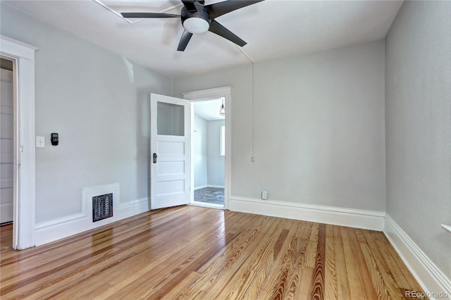 empty room with ceiling fan, light wood-style flooring, and baseboards