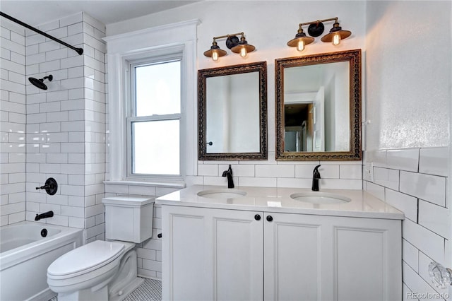 full bathroom featuring tile walls, toilet, double vanity,  shower combination, and plenty of natural light