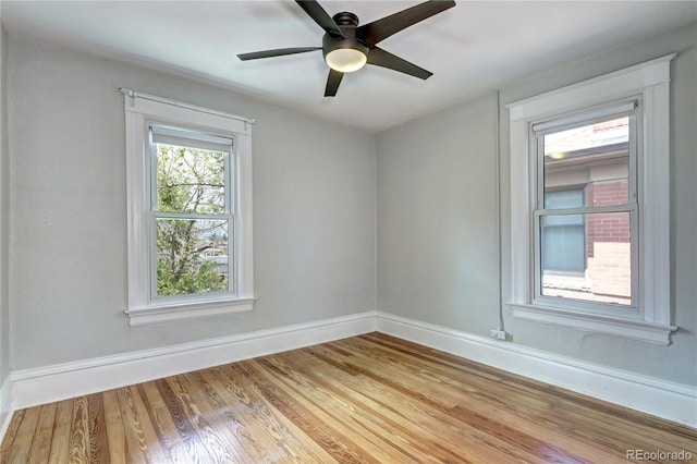 unfurnished room with wood finished floors, baseboards, and ceiling fan