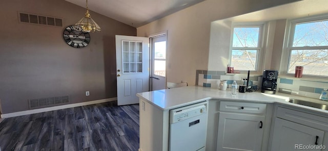 kitchen featuring dark wood-type flooring, vaulted ceiling, dishwasher, kitchen peninsula, and white cabinets