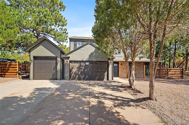 2020 Forest Ridge Dr, Colorado Springs, CO 80918 - traditional home featuring concrete driveway, stone siding, fence, and a garage