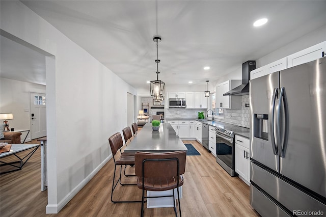 2020 Forest Ridge Dr, Colorado Springs, CO 80918 - kitchen with tasteful backsplash, wall chimney exhaust hood, a sink, stainless steel appliances, and light wood-style flooring