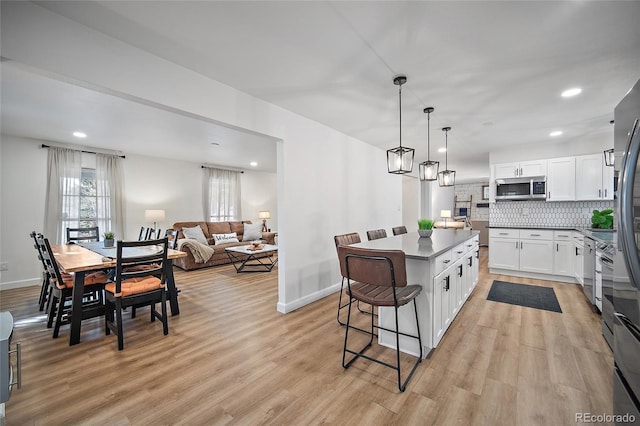 2020 Forest Ridge Dr, Colorado Springs, CO 80918 - kitchen with decorative backsplash, stainless steel microwave, baseboards, and a kitchen breakfast bar