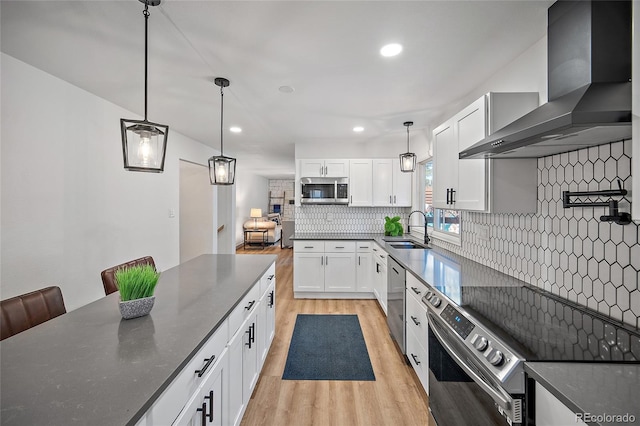 2020 Forest Ridge Dr, Colorado Springs, CO 80918 - kitchen featuring tasteful backsplash, light wood-type flooring, wall chimney range hood, stainless steel appliances, and a sink