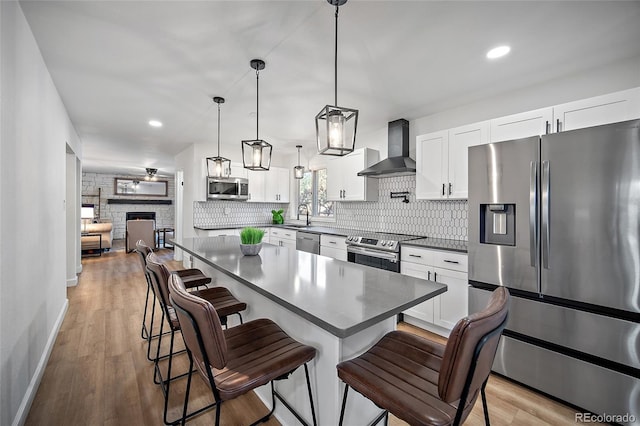 2020 Forest Ridge Dr, Colorado Springs, CO 80918 - kitchen featuring wall chimney exhaust hood, a sink, appliances with stainless steel finishes, backsplash, and a breakfast bar area