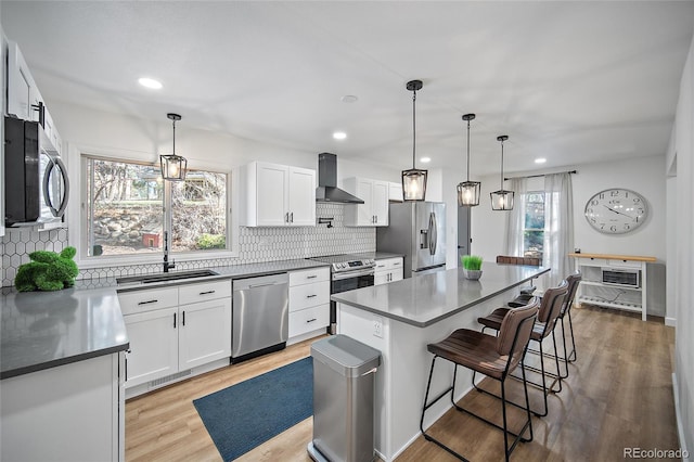 2020 Forest Ridge Dr, Colorado Springs, CO 80918 - kitchen with wall chimney exhaust hood, a sink, stainless steel appliances, decorative backsplash, and a breakfast bar area