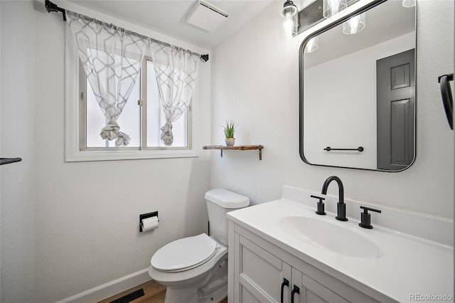 2020 Forest Ridge Dr, Colorado Springs, CO 80918 - half bathroom with vanity, baseboards, toilet, visible vents, and wood finished floors