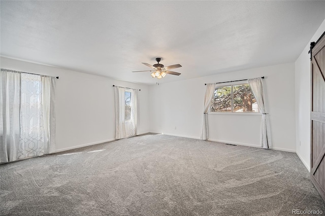 2020 Forest Ridge Dr, Colorado Springs, CO 80918 - unfurnished bedroom featuring a barn door, baseboards, and carpet