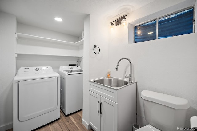 2020 Forest Ridge Dr, Colorado Springs, CO 80918 - washroom with laundry area, separate washer and dryer, wood finished floors, and a sink
