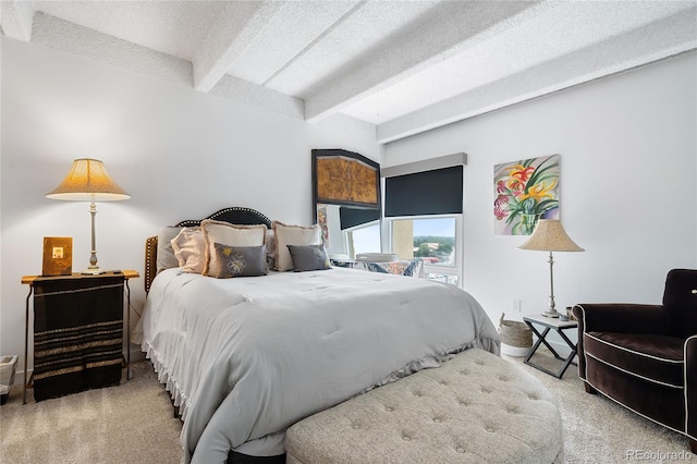 carpeted bedroom with beam ceiling and a textured ceiling