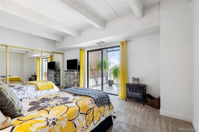 bedroom with access to outside, a textured ceiling, beam ceiling, and carpet flooring