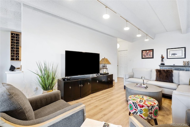 living room featuring beamed ceiling, hardwood / wood-style floors, and a textured ceiling