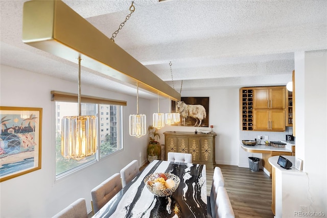 dining room with a textured ceiling and dark hardwood / wood-style flooring