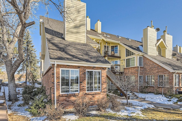 snow covered property with a balcony