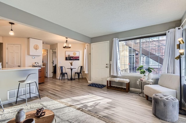 living room featuring a textured ceiling and light hardwood / wood-style flooring