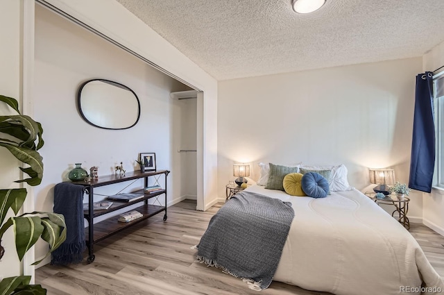 bedroom featuring a textured ceiling and light wood-type flooring