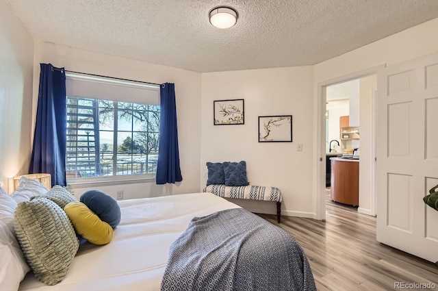 bedroom with hardwood / wood-style floors and a textured ceiling