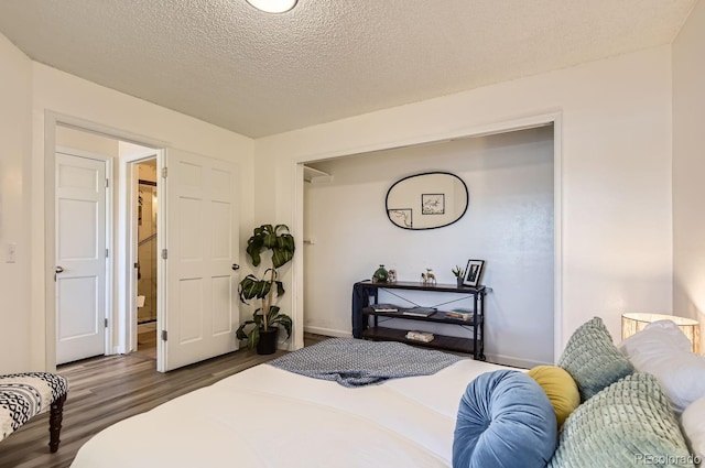 bedroom with dark wood-type flooring and a textured ceiling