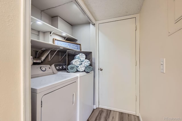 laundry room with separate washer and dryer and light hardwood / wood-style floors