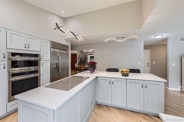 3743 W 103rd Dr, Westminster, CO 80031 - kitchen with stainless steel appliances, light wood-style flooring, light countertops, decorative light fixtures, and recessed lighting