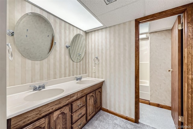 3743 W 103rd Dr, Westminster, CO 80031 - bathroom featuring double vanity, wallpapered walls, and a drop ceiling
