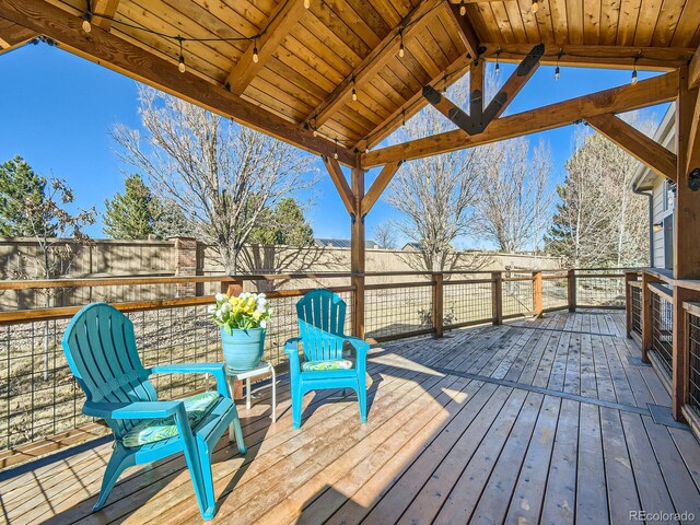 wooden deck with a fenced backyard