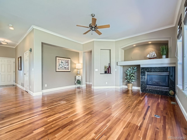 unfurnished living room featuring baseboards, a tiled fireplace, and wood finished floors