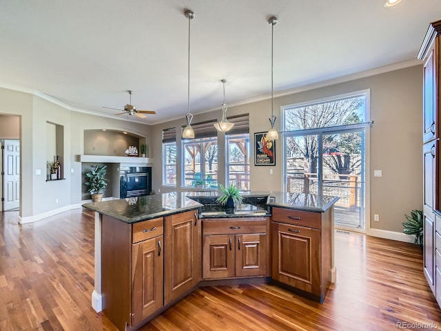 kitchen with ornamental molding, brown cabinets, and wood finished floors