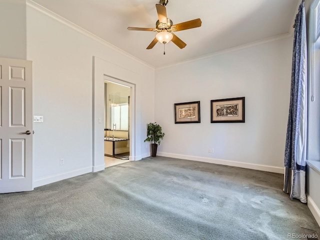 spare room with carpet, baseboards, ornamental molding, and a ceiling fan