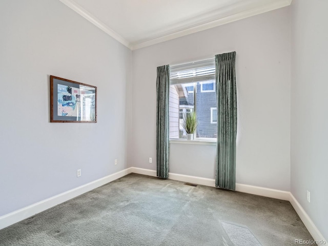 spare room with ornamental molding, carpet, visible vents, and baseboards