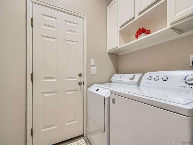 washroom featuring washing machine and clothes dryer and cabinet space