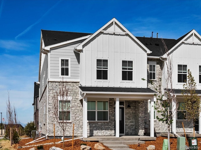 755 N Tibet St, Aurora, CO 80018 - view of front of house with stone siding, board and batten siding, and covered porch