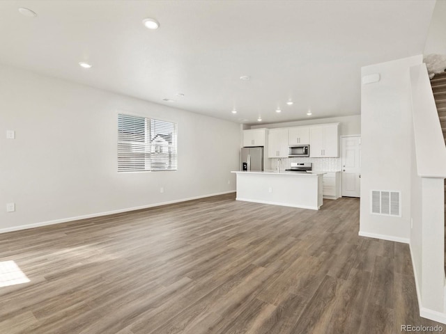 755 N Tibet St, Aurora, CO 80018 - unfurnished living room with recessed lighting, wood finished floors, and baseboards