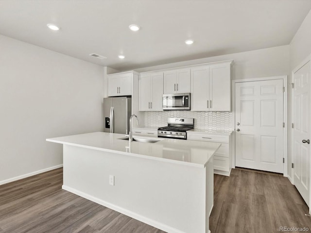 755 N Tibet St, Aurora, CO 80018 - kitchen featuring stainless steel appliances, a sink, an island with sink, backsplash, and white cabinets