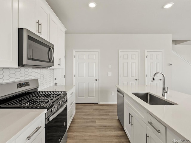 755 N Tibet St, Aurora, CO 80018 - kitchen featuring stainless steel appliances, a sink, light countertops, recessed lighting, and white cabinets