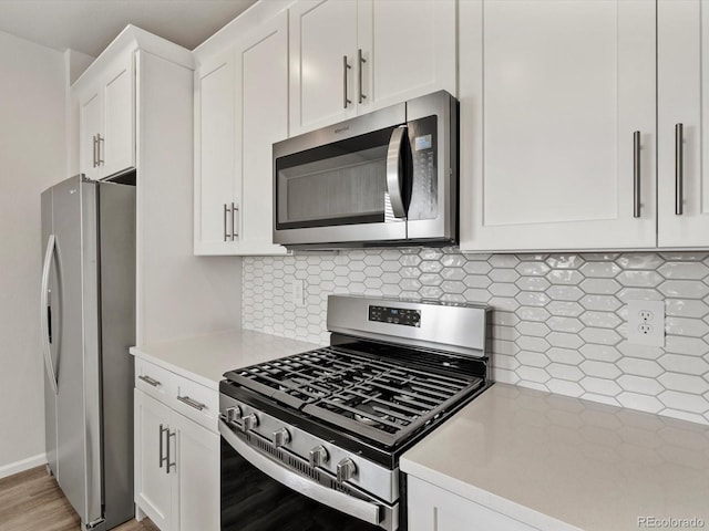 755 N Tibet St, Aurora, CO 80018 - kitchen featuring stainless steel appliances, light countertops, white cabinets, and decorative backsplash