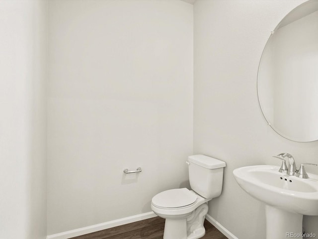 755 N Tibet St, Aurora, CO 80018 - bathroom with wood finished floors, baseboards, toilet, and a sink