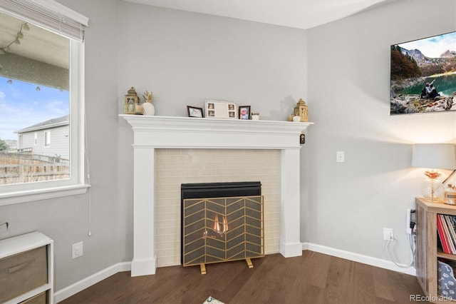 7268 Greenwater Cir, Castle Rock, CO 80108 - living room with a warm lit fireplace, baseboards, and dark wood finished floors