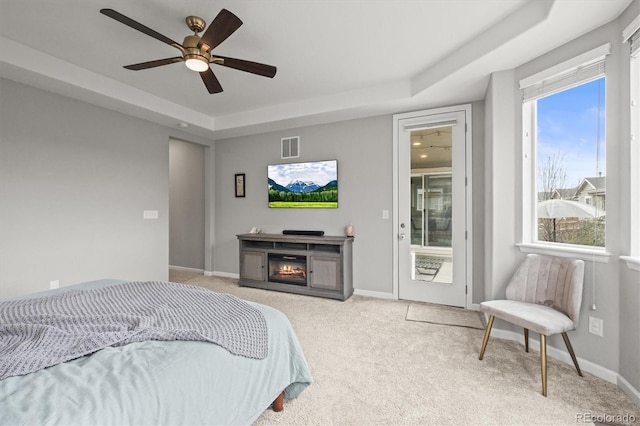 7268 Greenwater Cir, Castle Rock, CO 80108 - carpeted bedroom featuring access to exterior, a raised ceiling, visible vents, a glass covered fireplace, and baseboards