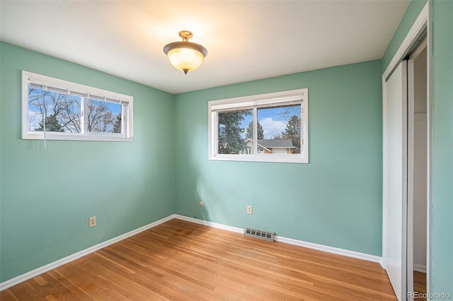 unfurnished bedroom with light wood-type flooring and a closet