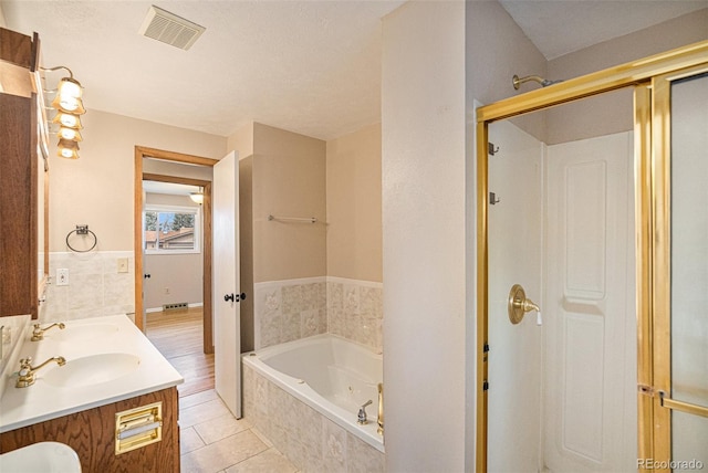 bathroom with plus walk in shower, tile patterned flooring, a textured ceiling, and vanity