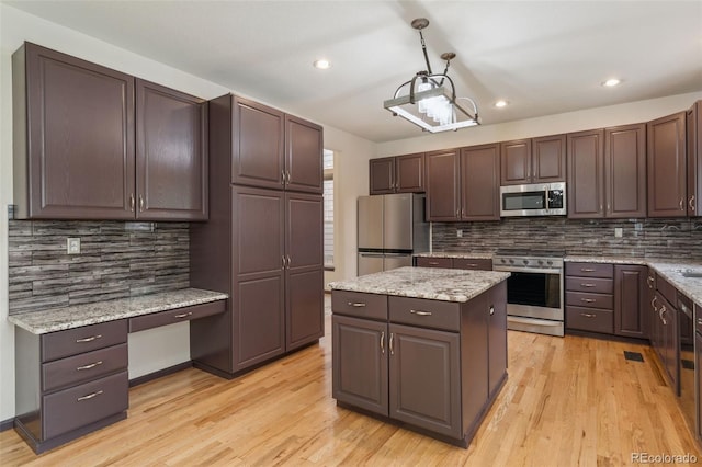 13486 Clayton St, Thornton, CO 80241 - kitchen featuring appliances with stainless steel finishes, backsplash, light wood-type flooring, recessed lighting, and a center island