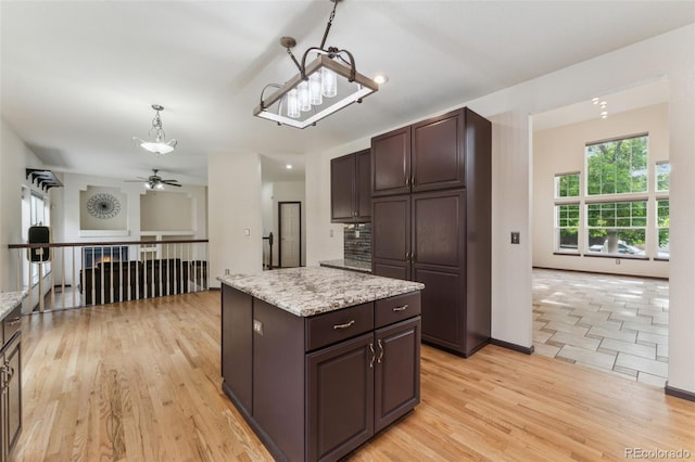 13486 Clayton St, Thornton, CO 80241 - kitchen featuring a chandelier, dark brown cabinets, light wood-style floors, a kitchen island, and ceiling fan