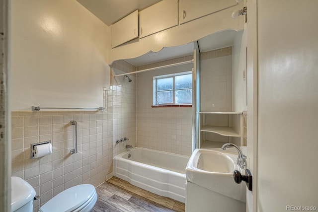 2226 N Greenwood St, Pueblo, CO 81003 - full bathroom with toilet, tile walls, wood finished floors, washtub / shower combination, and vanity