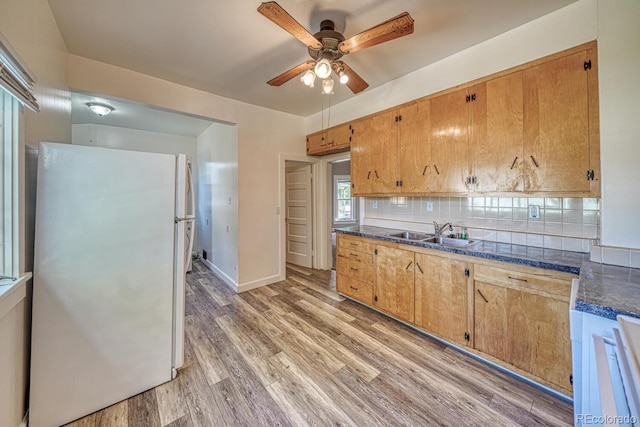 2226 N Greenwood St, Pueblo, CO 81003 - kitchen with freestanding refrigerator, a sink, dark countertops, a ceiling fan, and light wood-style flooring